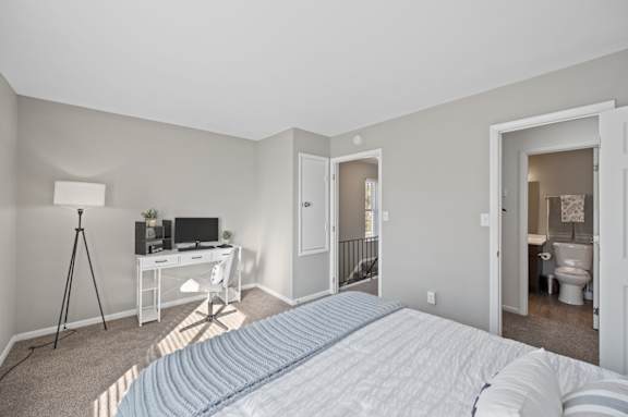 A bedroom with a bed, desk, chair, and a window. at The Parkton, Cincinnati