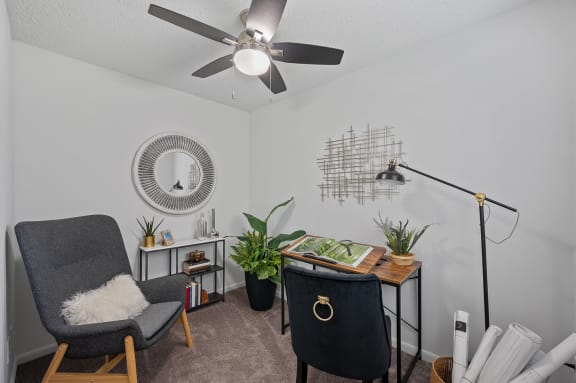 an office with a ceiling fan and a desk with a chair