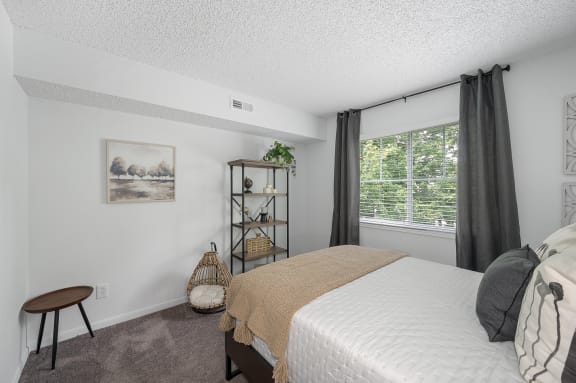 a bedroom with a bed and a large window