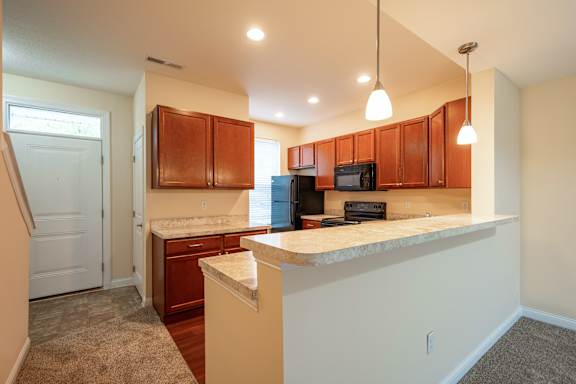 A kitchen with brown cabinets and a white counter.
