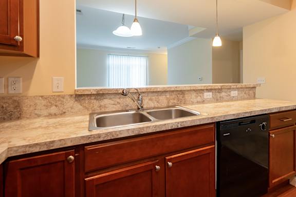 A kitchen with a marble countertop and wooden cabinets.