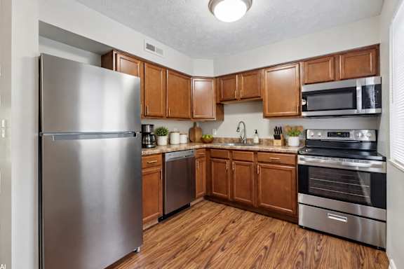 A kitchen with wooden cabinets and stainless steel appliances.