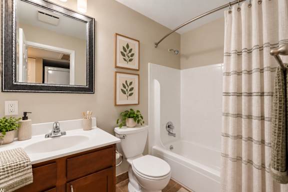 A bathroom with a toilet, sink, and shower.