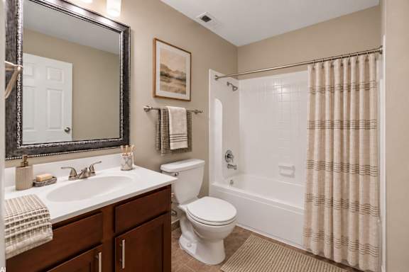 A bathroom with a toilet, sink, and shower.
