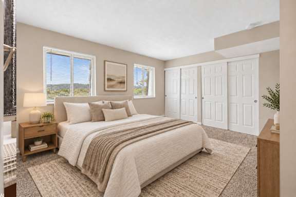A bedroom with a large bed and a view of the outdoors through the window.