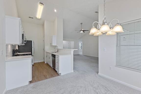 A kitchen with white appliances and cabinets is shown.