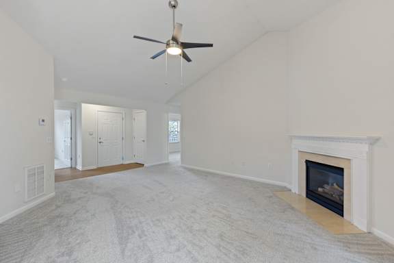 A spacious living room with a fireplace and a ceiling fan.