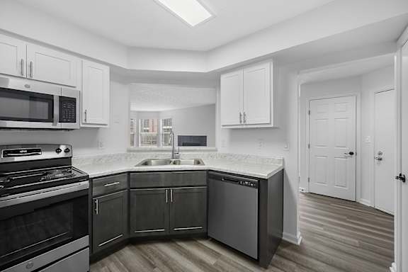 A kitchen with black appliances and white cabinets at Indian Lookout Apartments, West Carrollton, 45449
