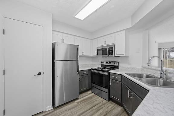 A modern kitchen with a refrigerator, oven, and microwave at Indian Lookout Apartments, Ohio, 45449