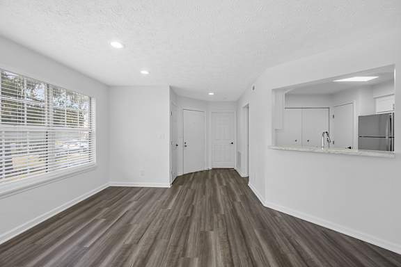 A room with wooden flooring and white walls at Indian Lookout Apartments, West Carrollton