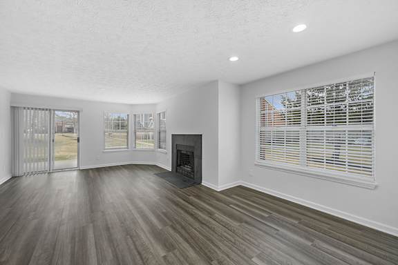 A room with a fireplace and sliding glass doors at Indian Lookout Apartments, West Carrollton, Ohio