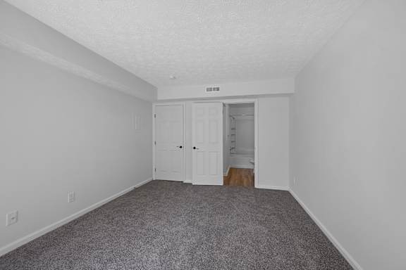 A room with a grey carpet and white walls at Indian Lookout Apartments, West Carrollton, OH