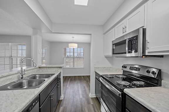 A kitchen with a stove, sink, and cabinets at Indian Lookout Apartments, West Carrollton, 45449