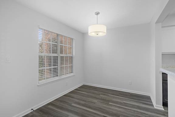 A room with a window covered by blinds and a light hanging from the ceiling at Indian Lookout Apartments, Ohio