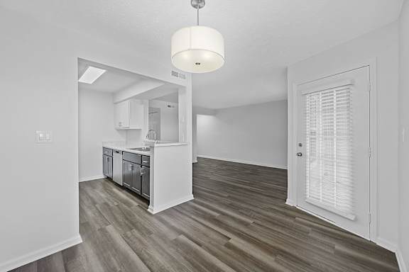 A kitchen with white cabinets and a wooden floor at Indian Lookout Apartments, Ohio