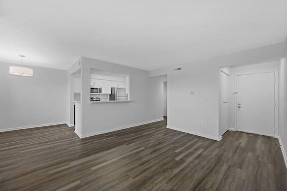 A spacious room with wooden flooring and white walls at Indian Lookout Apartments, West Carrollton