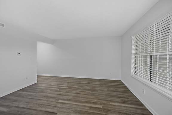 A room with wooden flooring and white walls at Indian Lookout Apartments, West Carrollton