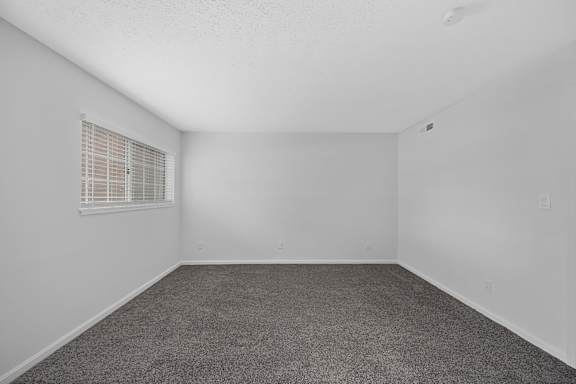 A room with a carpeted floor and a window with blinds at Indian Lookout Apartments, Ohio, 45449