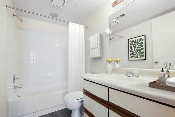 A white bathroom with a toilet, sink, and bathtub.