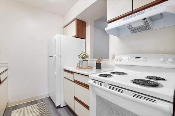 A white stove and refrigerator in a kitchen.