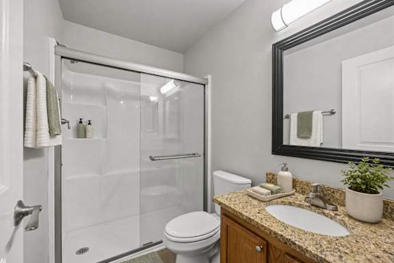 A bathroom with a toilet, sink, and shower.