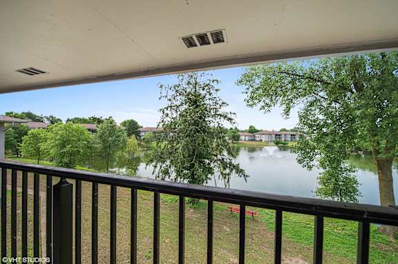 A balcony overlooks a body of water with trees in the background. at 7 Pointe Apartments, Indianapolis, 46205