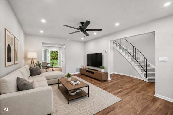 A living room with a couch, a coffee table, and a staircase.