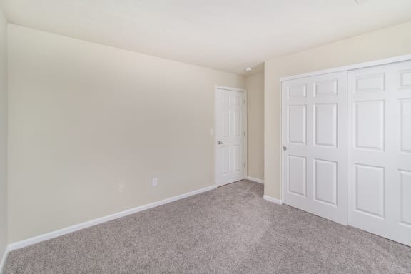 Bedroom with white doors and carpeting