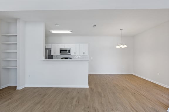 an empty living room and kitchen with white walls and wood flooring at Four Bridges, Liberty Township, 45044-8380