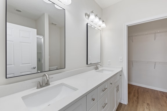 a white bathroom with two sinks and a large mirror at Four Bridges, Liberty Township, Ohio