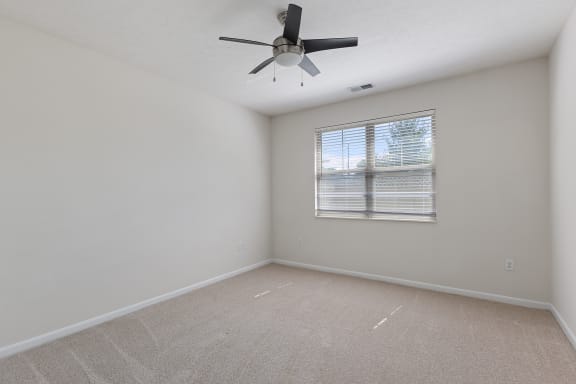 an empty room with a ceiling fan and a window at Four Bridges, Liberty Township, OH