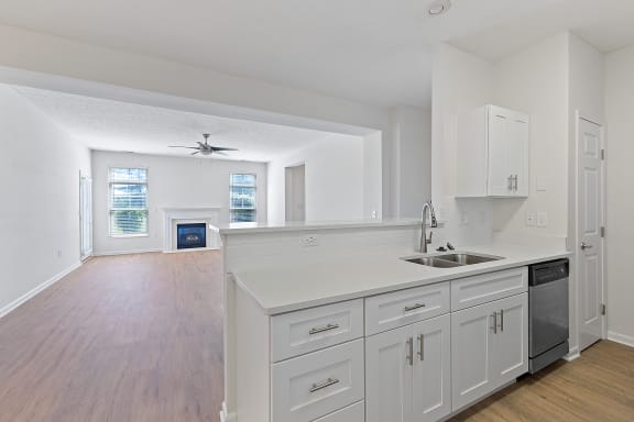 an empty kitchen with white cabinets and a sink at Four Bridges, Liberty Township