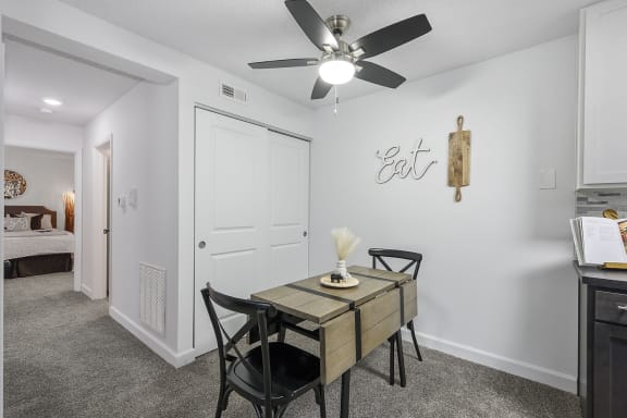 Dining room table with 4 chairs and a ceiling fan