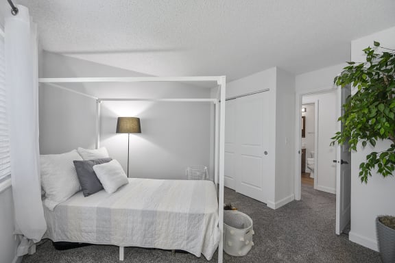 Bedroom with a large white bed and a white closet