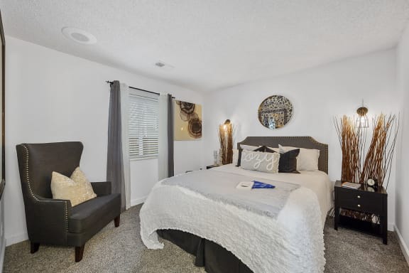 Bedroom with a large bed and a chair