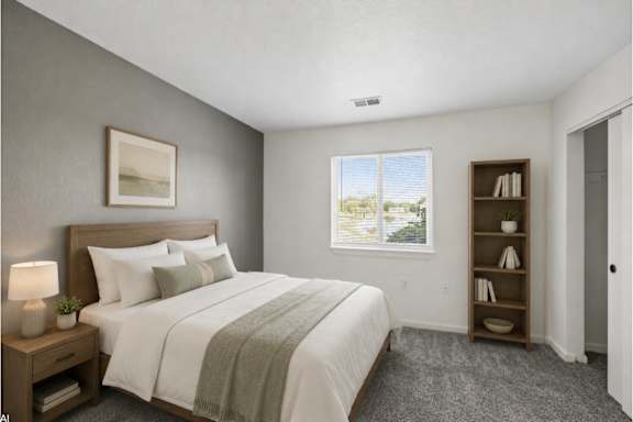 A bedroom with a large bed and a window overlooking a landscape.