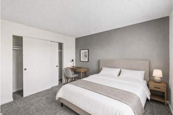 A bedroom with a bed, desk, and chair.