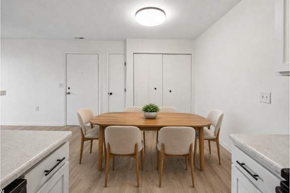 A dining room with a table and chairs.