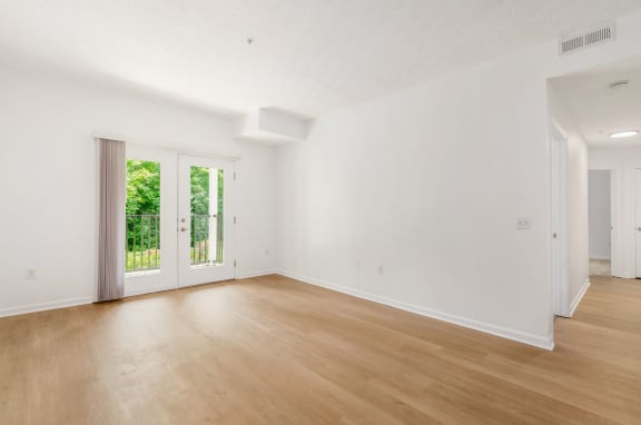 an empty living room with white walls and wood floors