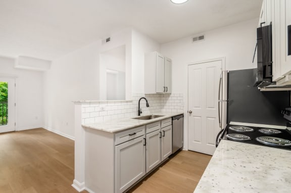 a renovated kitchen with white cabinets and a white counter top