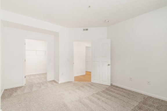 an empty living room with white walls and a carpet