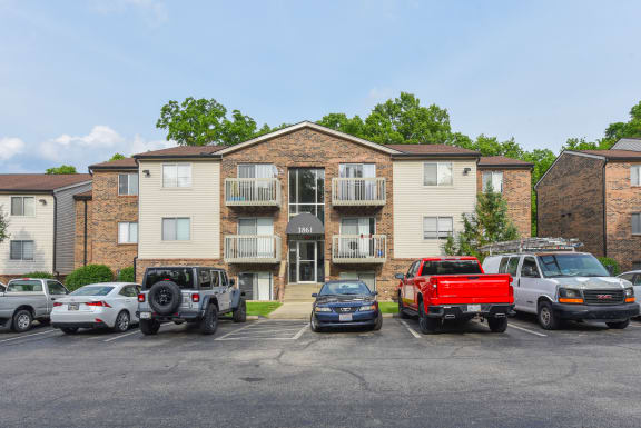 an apartment building with cars parked in front of it at The Woodridge Collection, Ohio