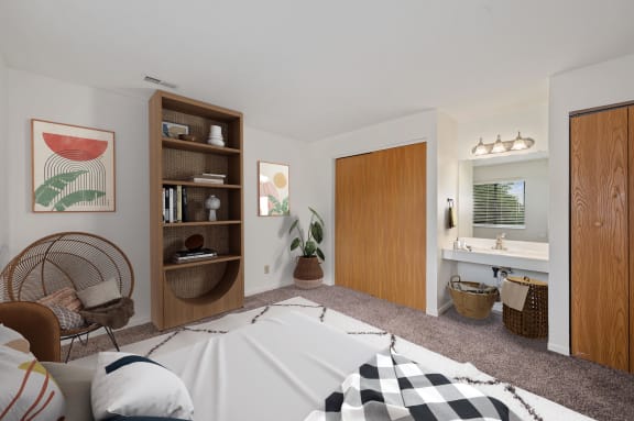 a bedroom with a bed and a bathroom with a sink and a mirror at The Woodridge Collection, Fairfield, OH