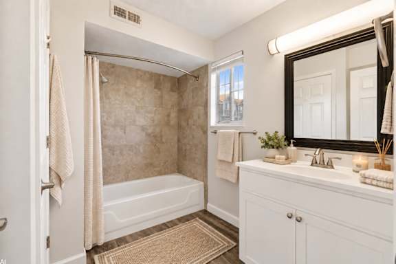 A bathroom with a tub, sink, and mirror.