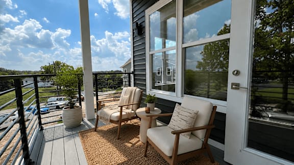 A balcony with two chairs and a table.