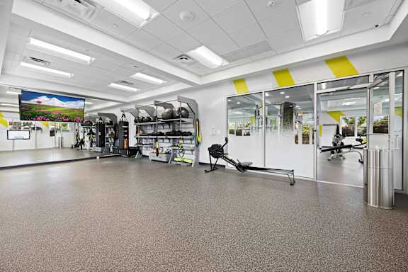 A gym with a variety of equipment including treadmills, weights, and exercise machines at Rose Hill Apartments, Alexandria, Virginia