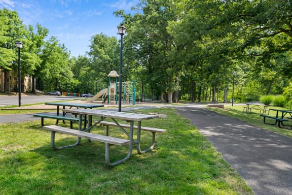 a group of picnic tables next to a playground in a park at Stuart Woods* Apartments, Virginia, 20170