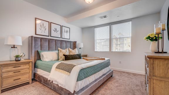 A bedroom with a large bed, a dresser, and a nightstand.