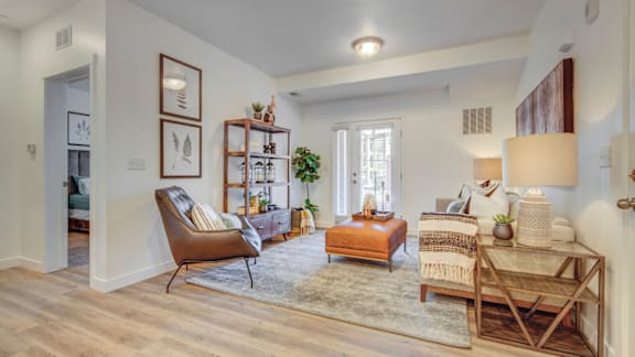 A living room with a chair, a table, and a rug.