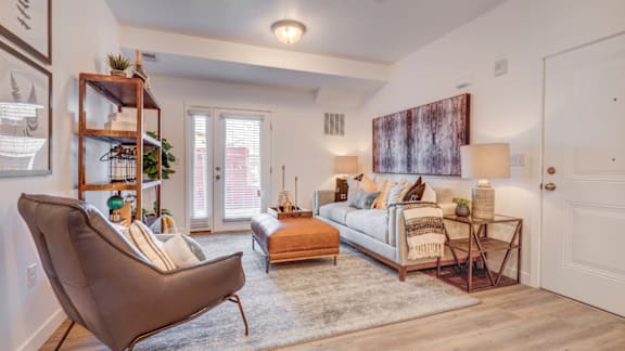 A living room with a brown chair and a white couch.
